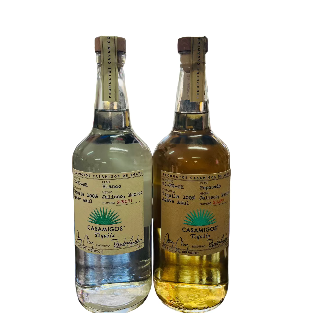 Two bottles of Casamigos tequila on a bar counter with a blurred bar background.