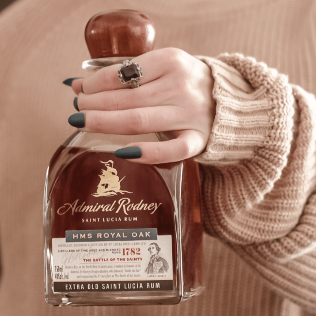 Hand holding a bottle of Admiral Rodney Saint Lucia Rum with a blurred background