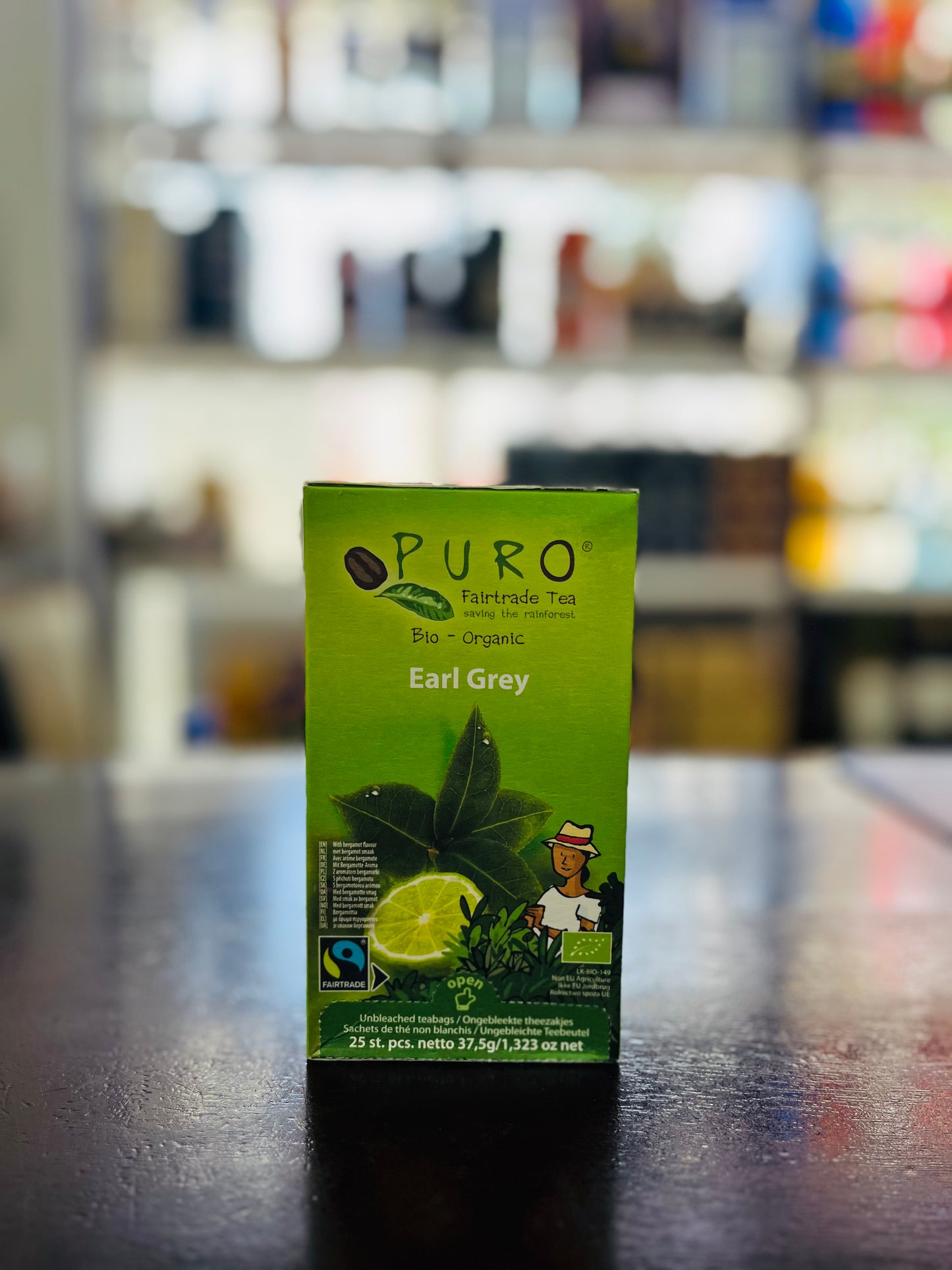 Puro Earl Grey tea box on a dark surface with a blurred background