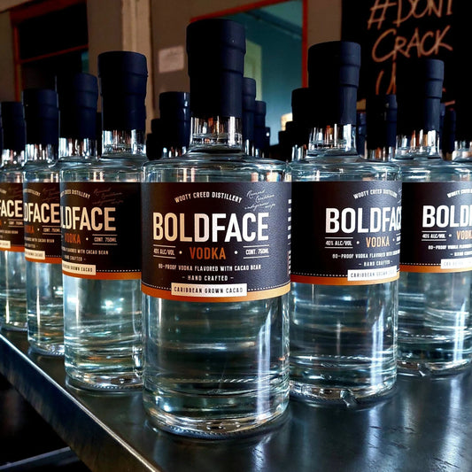 Row of Boldface Vodka bottles on a counter with a blurred background.