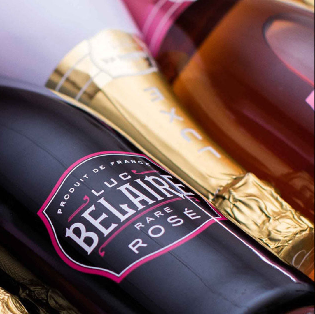 Close-up of Belair Rose champagne bottles with gold foil labels.
