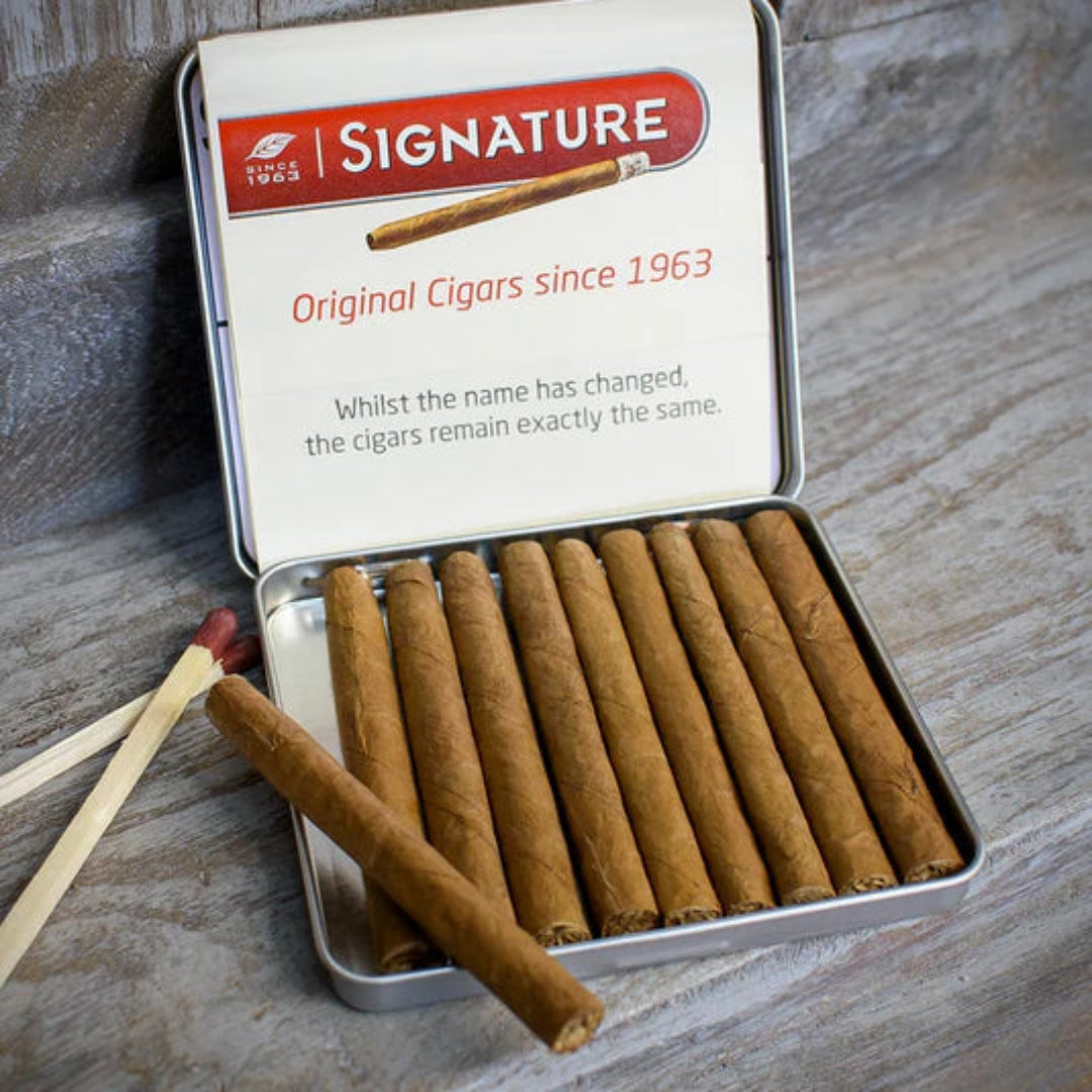 Open tin of Signature cigars with a match on a wooden surface