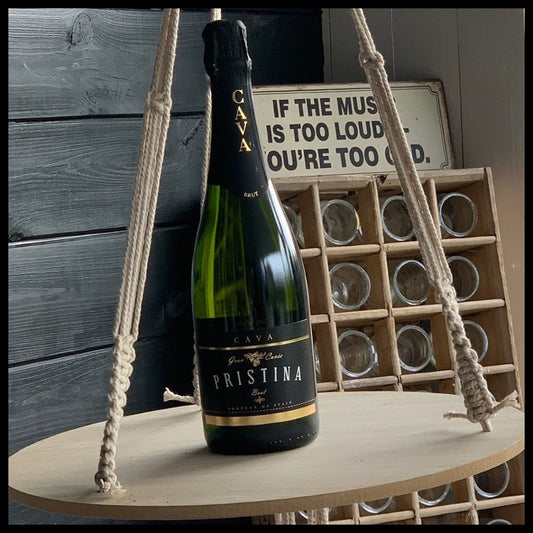 Pristina Cava bottle on a wooden stand with a rustic background