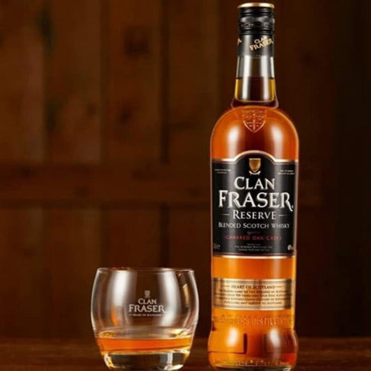 Clan Fraser Reserve blended Scotch whisky bottle with a glass on a wooden surface