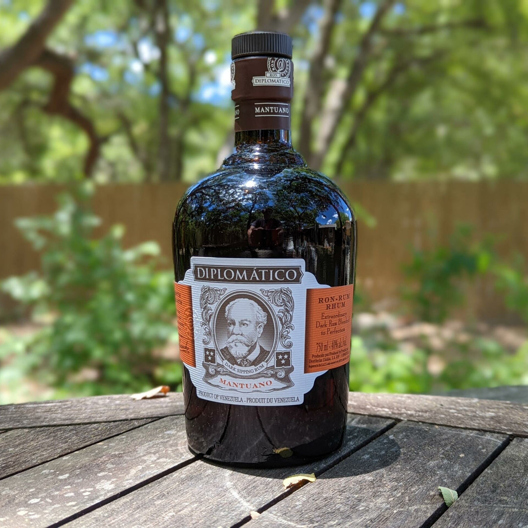Bottle of Diplomatico rum on a wooden surface with a blurred natural background