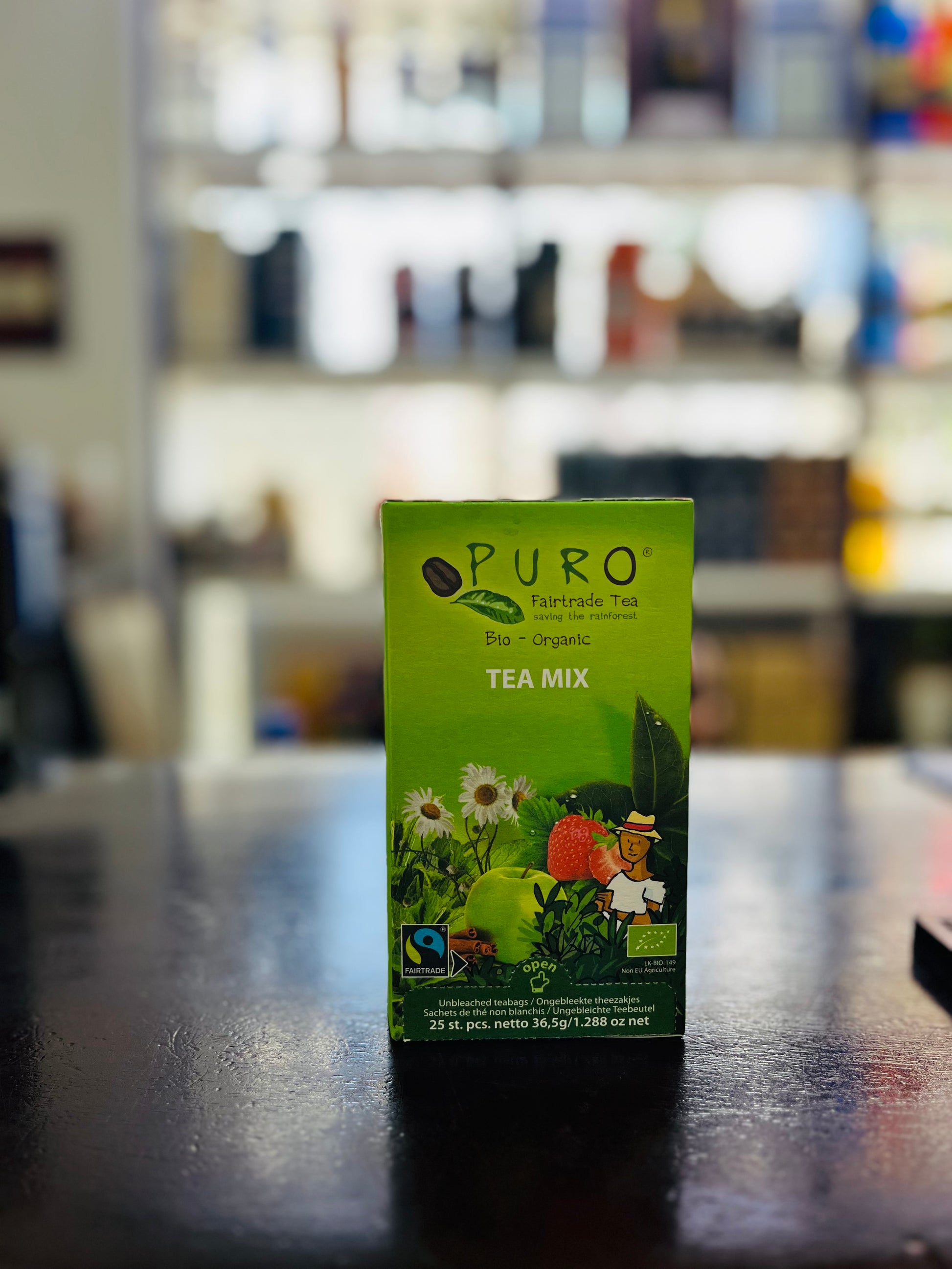 Puro tea mix box on a dark surface with a blurred background