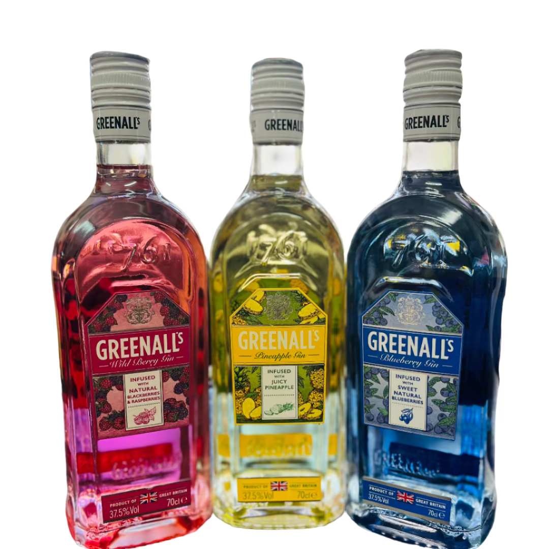 Three bottles of Greenall's liquor on a bar counter with a blurred bar background.