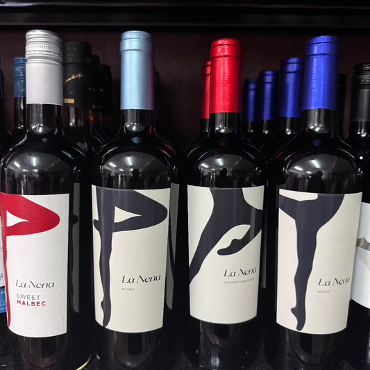 Row of wine bottles with 'La Nena' labels on a shelf.