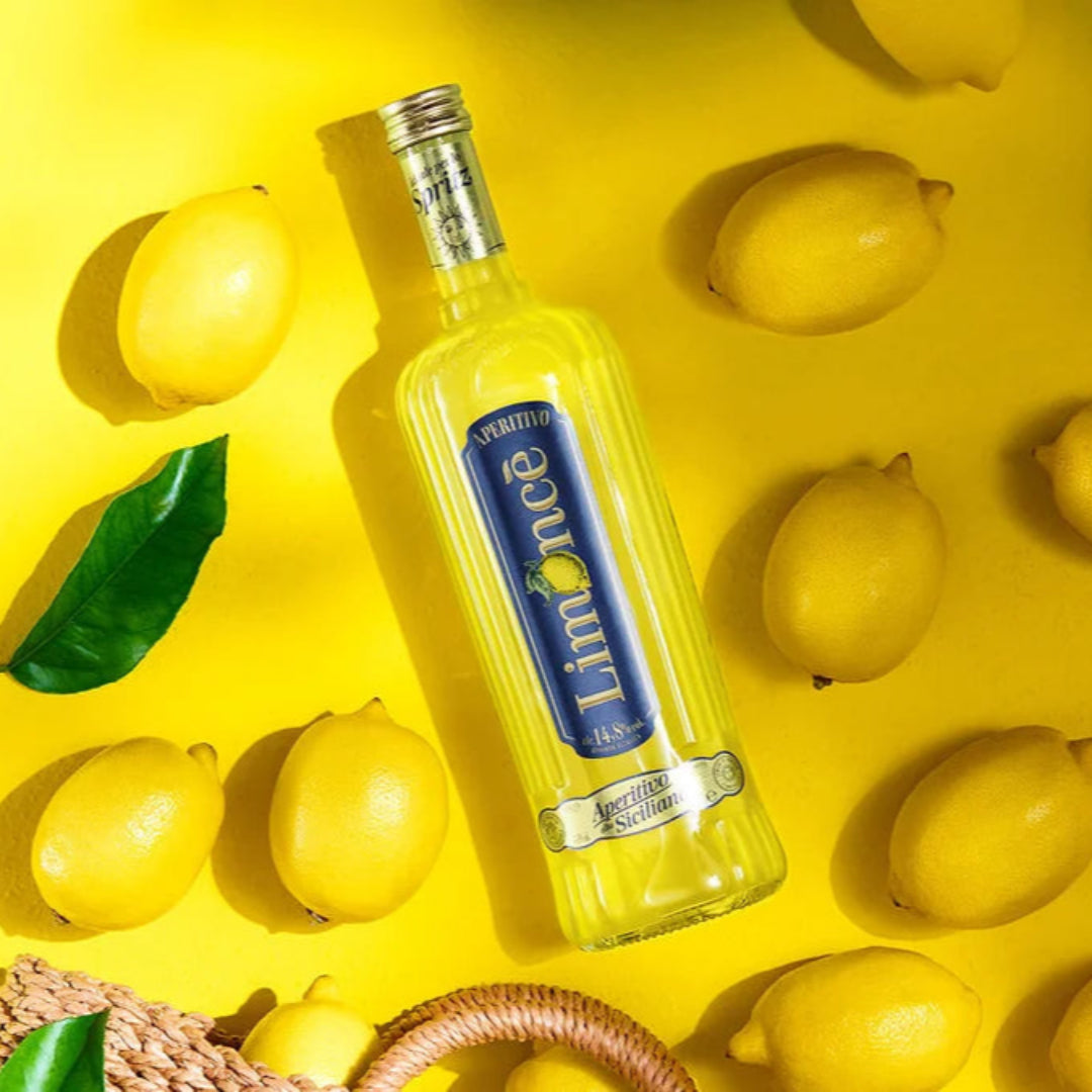 Bottle of Limoncello with lemons on a yellow background