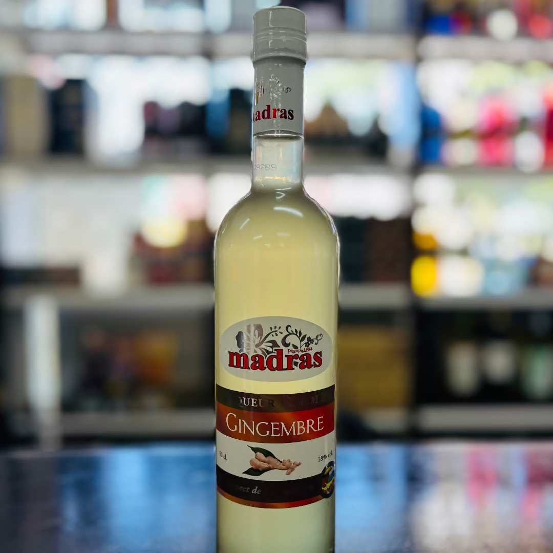 Bottle of Madras ginger liqueur on a bar counter with a blurred bar background