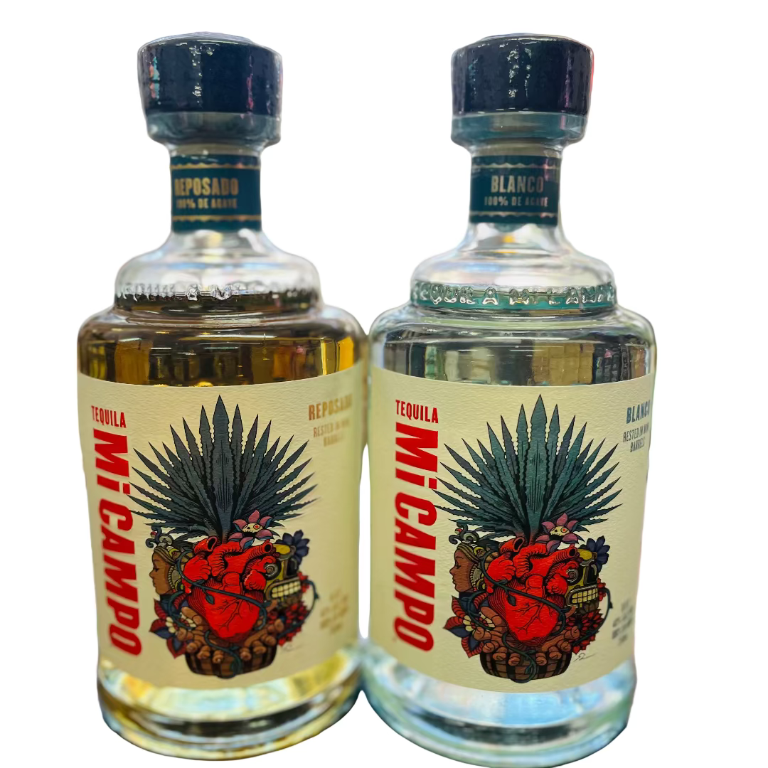 Two bottles of Mezcal on a bar counter with a blurred bar background