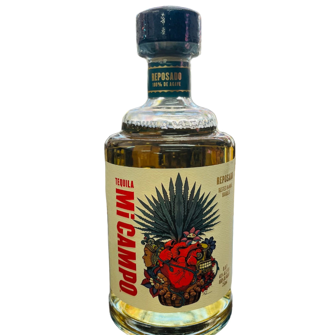 Tequila bottle labeled 'Mi Campo' on a bar counter with shelves of other bottles in the background