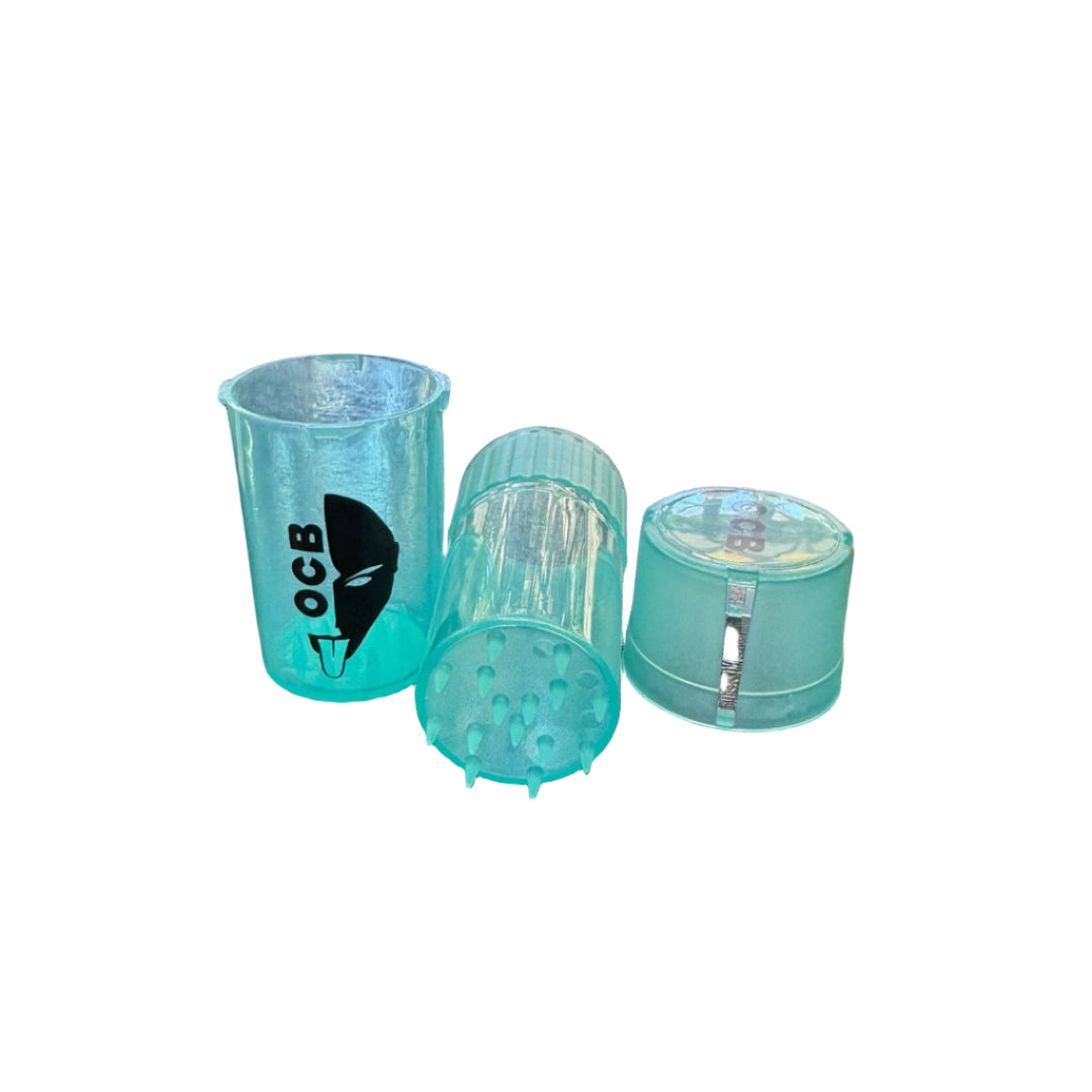 Three turquoise plastic cups on a bar counter with bottles in the background