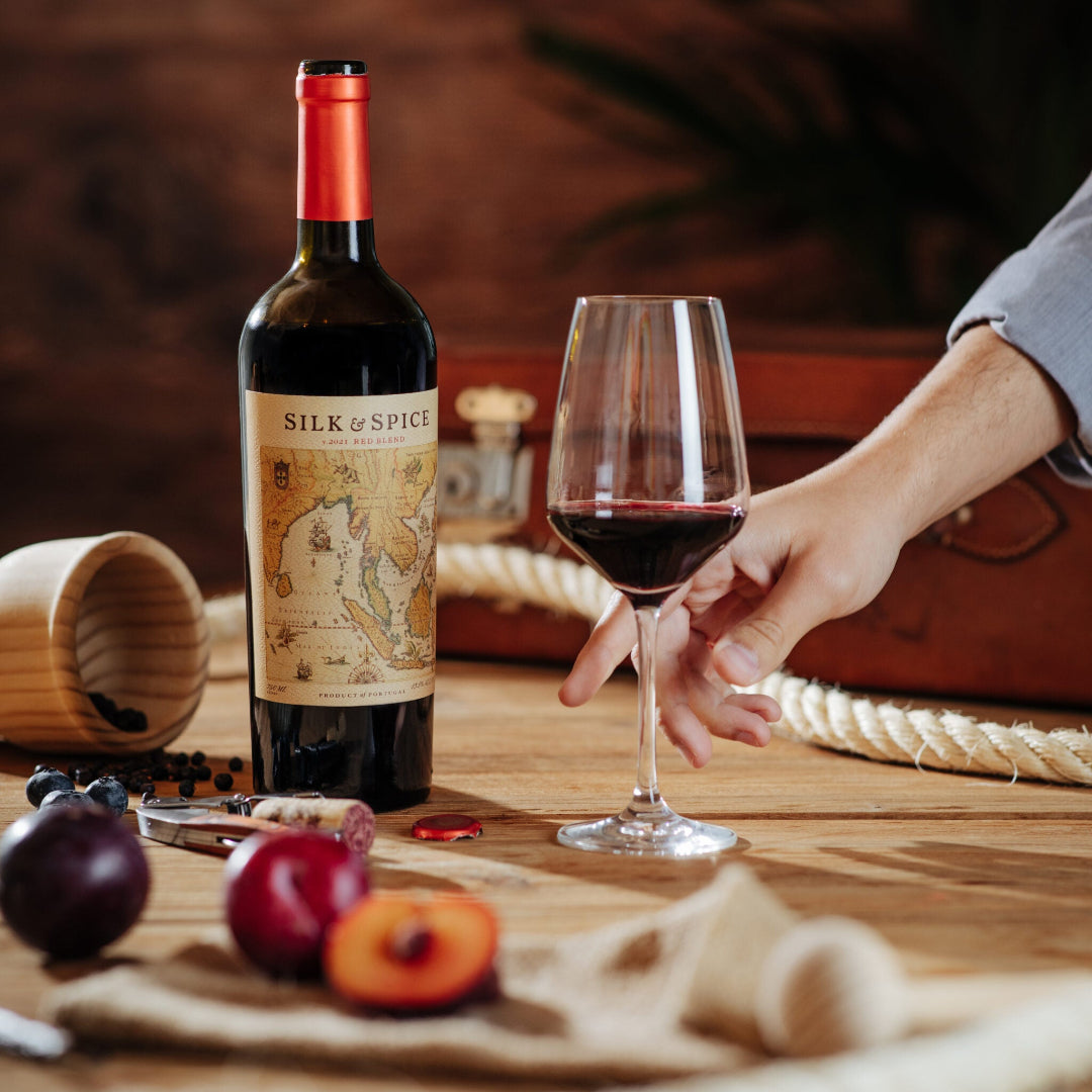 Bottle of Silk of Spice wine with a glass on a wooden table.