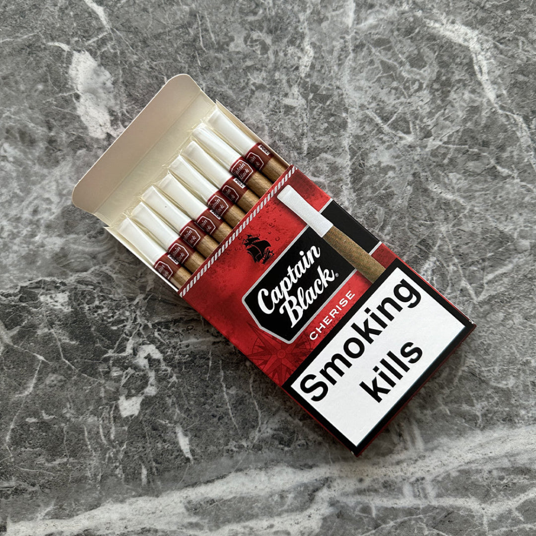 Open pack of Captain Black cherise cigarettes on a marble surface